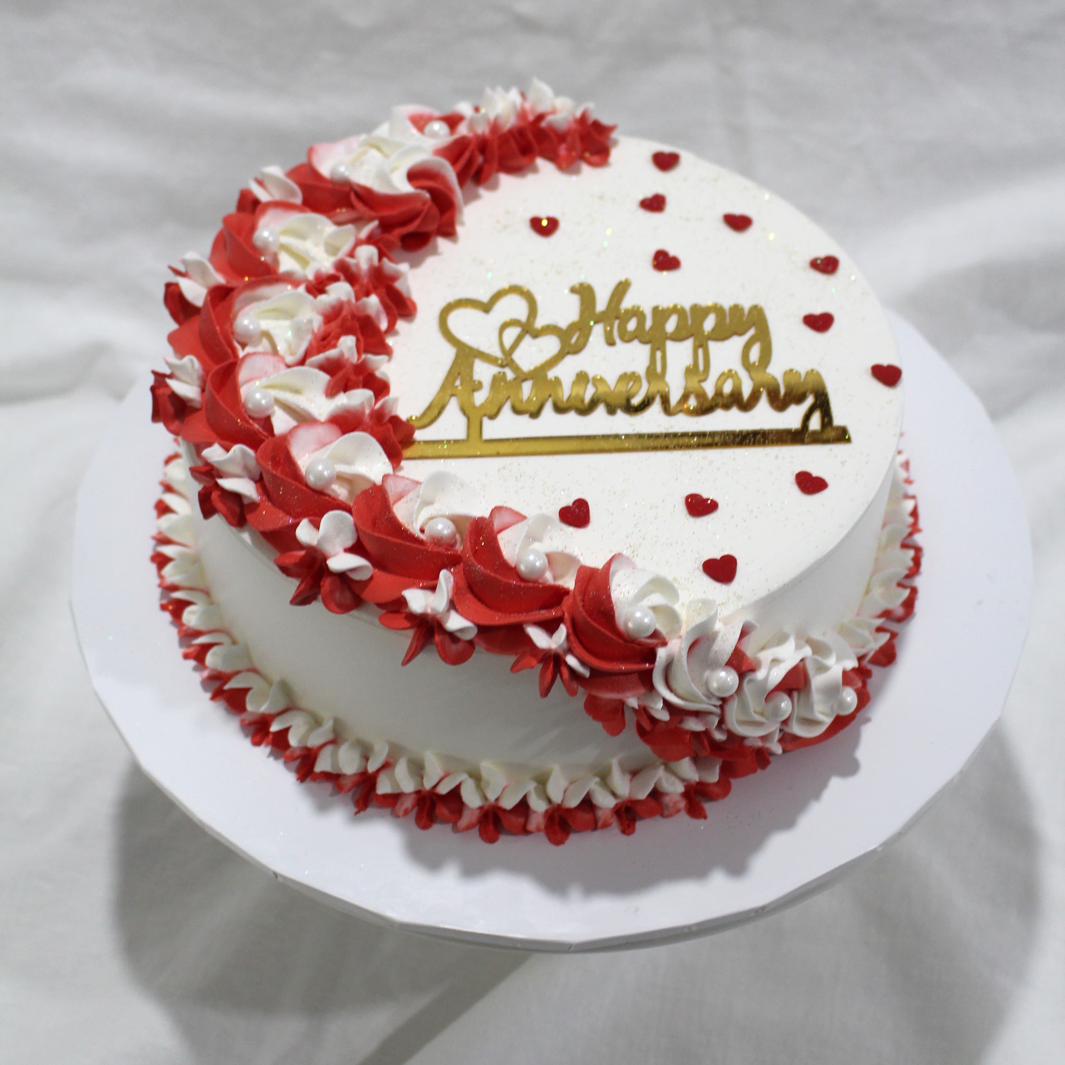 Vintage-style cake with red and white rosette piping and sugar pearls