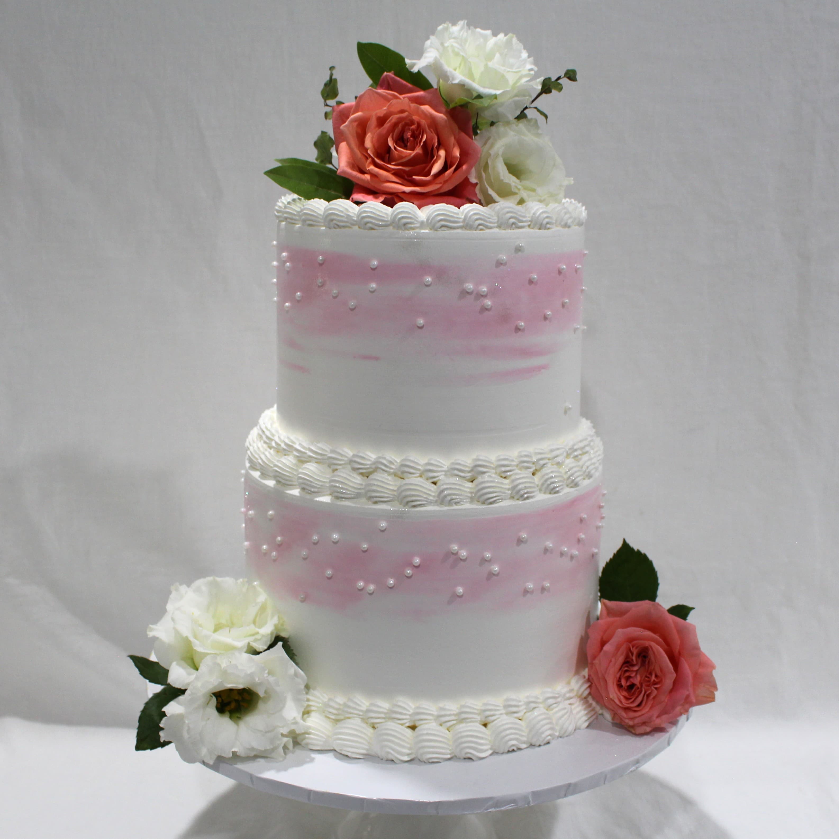 Two-tier blush wedding cake with fresh pink and white roses